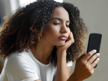 Frau schaut frustriert auf ihr Handy | © Getty Images/bymuratdeniz