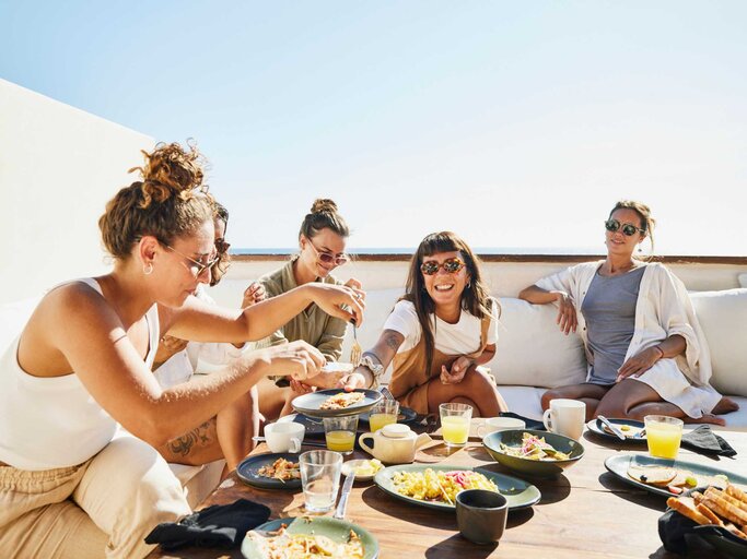 Gruppe von Frauen isst zusammen | © Getty Images/Thomas Barwick