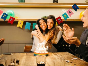 Junge Frau feiert Geburtstag und wird von ihrer Freundin umarmt | © Getty Images/Jordi Salas