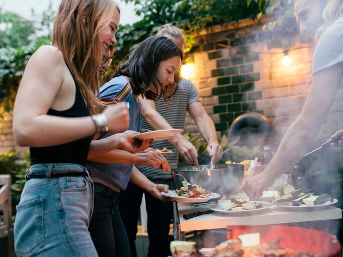 Gruppe von Freund*innen grillt zusammen | © Getty Images/Hinterhaus Productions