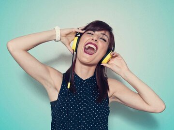 Frau trägt Kopfhörer und singt laut | © Getty Images/Francesco Carta fotografo