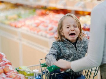 Quengelndes, weinendes Kleinkind im Einkaufswagen | © Getty Images/FangXiaNuo