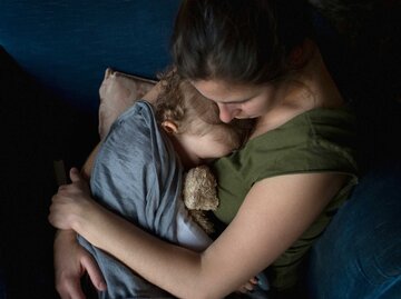 Frau kuschelt mit ihrem Kind | © Getty Images/Jerome Tisne