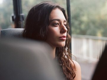 Frau sitzt nachdenklich im Bus und schaut aus dem Fenster | © Getty Images/Friend of Mars