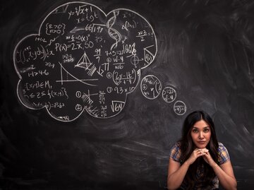 Mädchen denkt über Mathe-Gedankenblase auf der Tafel nach | © GettyImages/Justin Lewis