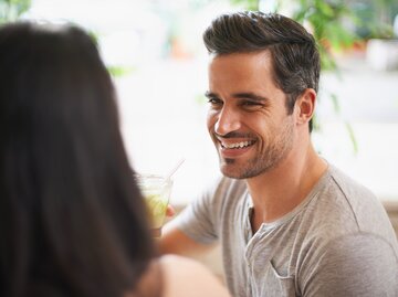 Mann ist auf einem Date mit einer Frau und lächelt | © Getty Images/PeopleImages