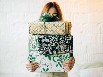 Frau mit vielen Geschenken in der Hand | © Getty Images/Fiordaliso