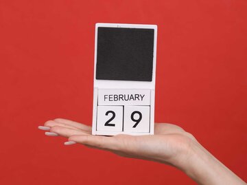 Kalender 29. Februar steht auf einer Frauenhand | © Getty Images/Vladimir Sukhachev