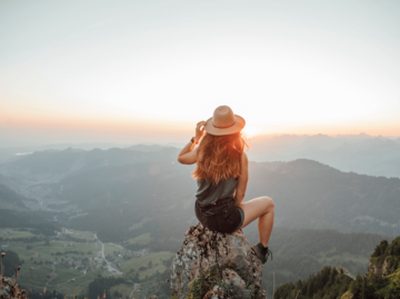 Frau sitzt auf Felsen | © Getty Images/Westend61