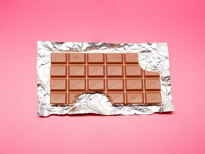 Tafel Schokolade auf rosa Hintergrund | © Getty Images/the_burtons