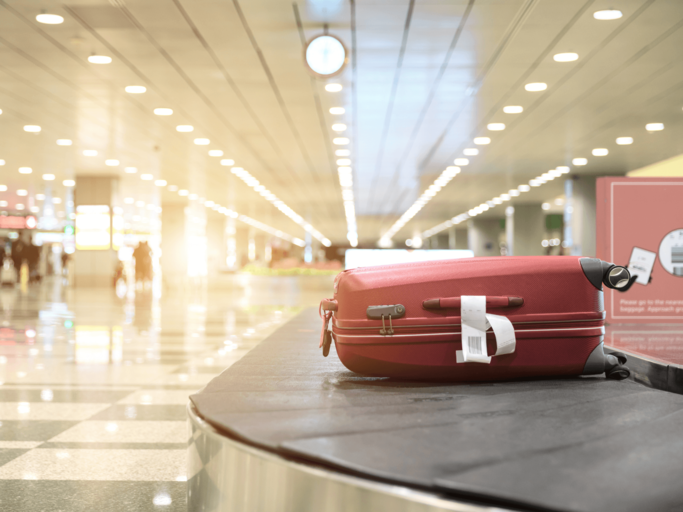 Roter Koffer auf Kofferband am Flughafen | © Getty Images/Lu ShaoJi