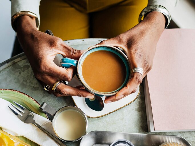 Frauenhände greifen nach Kaffeetasse | © Getty Images/Hinterhaus Productions