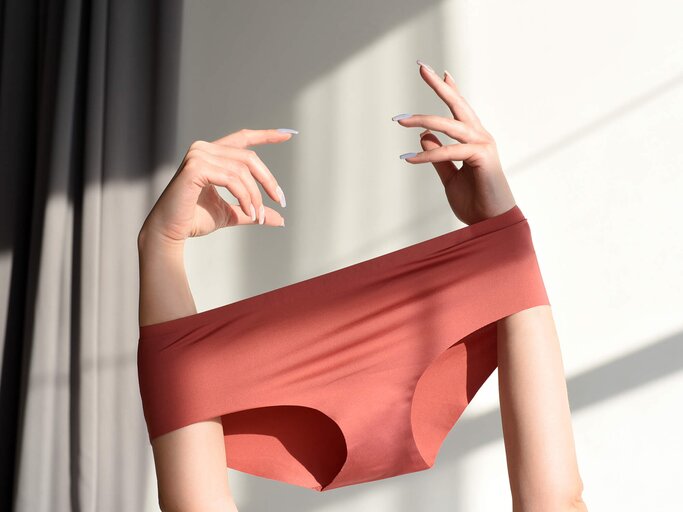Frau hat Unterhose zwischen den Händen gestülpt | © Getty Images/Maryna Terletska