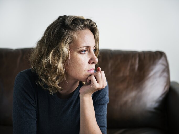 Frau schaut nachdenklich aus dem Fenster | © Getty Images/Rawpixel