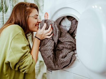 Frau riecht an frisch gewaschener Kleidung | © Getty Images/bojanstory