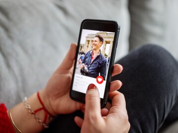 Frau schaut sich ein Dating Profil von einem Mann an | © Getty Images/Luis Alvarez