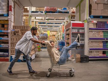 Mann schiebt Frau im Einkaufswagen durch den Discounter | © Getty Images/Smile