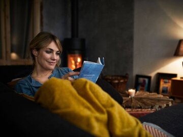 Person auf Couch liest Buch | © Getty Images/Westend61