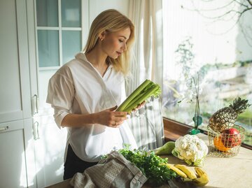 Frau hält Sellerie in den Händen | © Getty Images/Anastasiia Krivenok