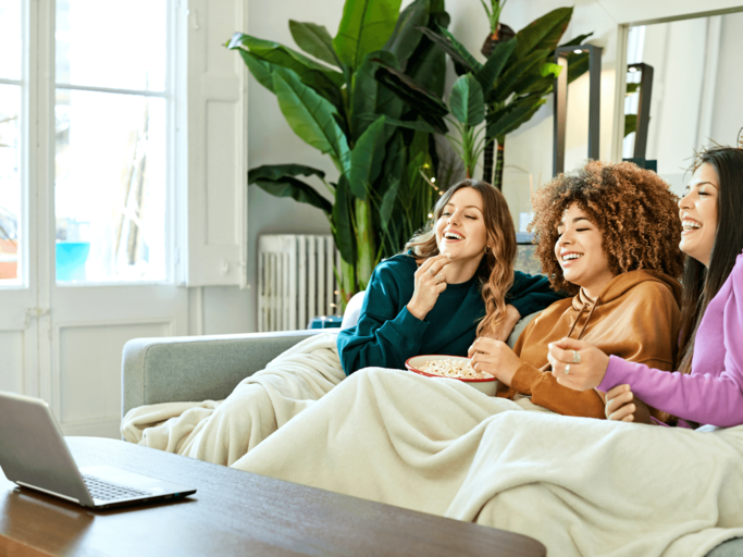 Drei Frauen schauen Film auf Laptop | © Getty Images/Morsa Images