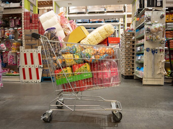 Voller Einkaufswagen im Discounter | © Getty Images/Smile