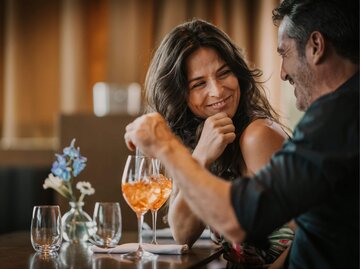 Frau und Mann flirten bei Cocktails | © Getty Images/Westend61