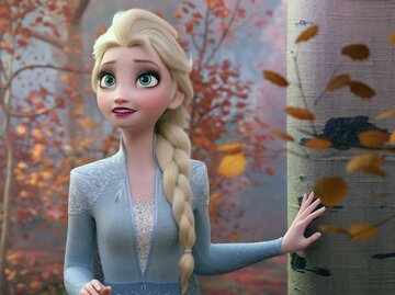 Disney-Prinzessin Elsa steht an einem Baum. | © IMAGO / Everett Collection