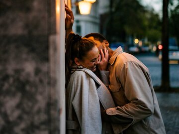 Junge Frau wird von ihrem Partner auf die Wange geküsst | © Getty Images/Janina Steinmetz