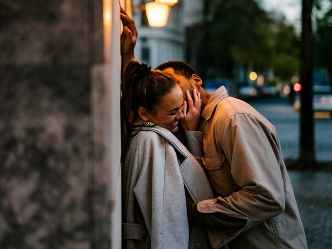 Junge Frau wird von ihrem Partner auf die Wange geküsst | © Getty Images/Janina Steinmetz