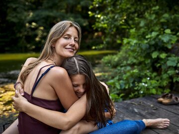 Frau umarmt Tochter | © Getty Images/Oliver Rossi