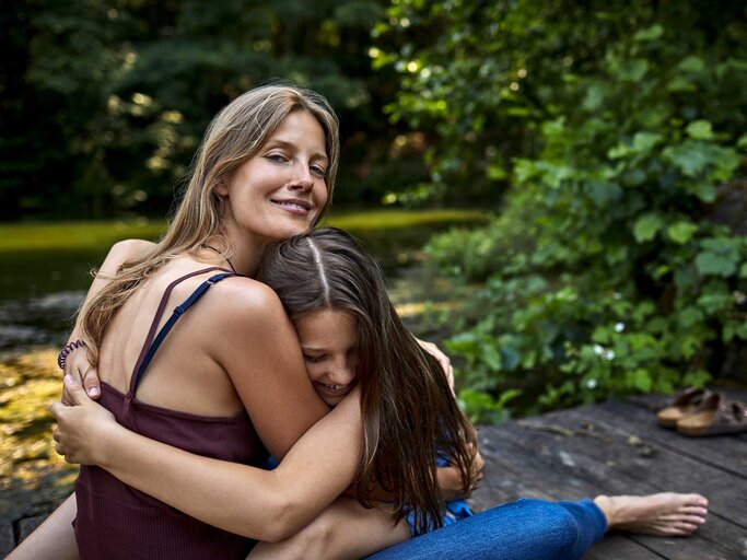 Frau umarmt Tochter | © Getty Images/Oliver Rossi