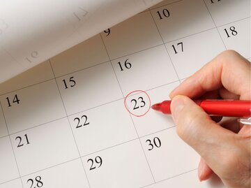 Hand streicht Datum in Kalender an | © Getty Images/kyoshino
