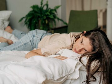 Frau liegt traurig auf ihrem Bett | © Getty Images/ilona titova