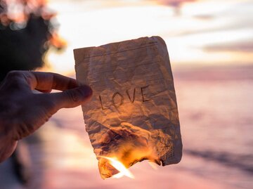 Brennendes Blatt Papier mit der Aufschrift "Love" | © Getty Images/bingokid