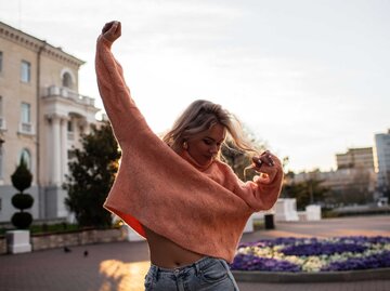 Frau tanzt ausgelassen auf der Straße | © Adobe Stock/Вероника Зеленина