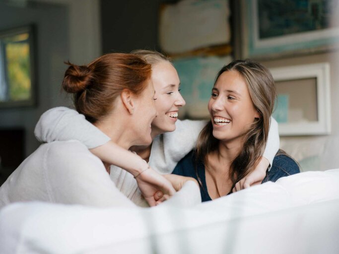 Drei junge Frauen lachen zusammen | © Getty Images/Westend61