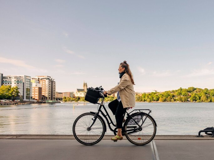 Person fährt auf Fahrrad an Fluss | © Getty Images/ Maskot