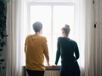 Frau und Mann schauen aus dem Fenster | © Getty Images/Maskot