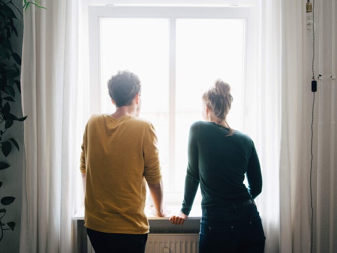Frau und Mann schauen aus dem Fenster | © Getty Images/Maskot