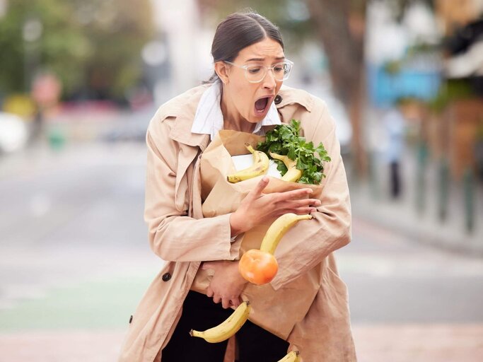 Frau mit aufreißender Einkaufstüte | © Getty Images/PeopleImages