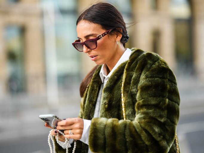 Frau schaut auf ihr Smartphone | © Getty Images/Edward Berthelot 