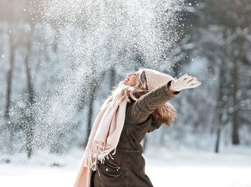 Frau wirft Schnee in die Luft | © Getty Images/Tijana87