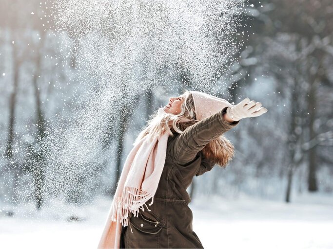 Frau wirft Schnee in die Luft | © Getty Images/Tijana87