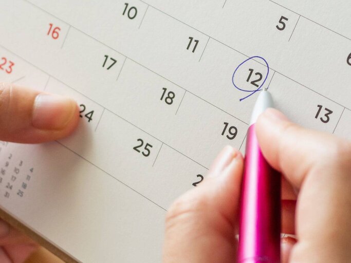 Hand streicht Datum in Kalender an | © Getty Images/Kwangmoozaa