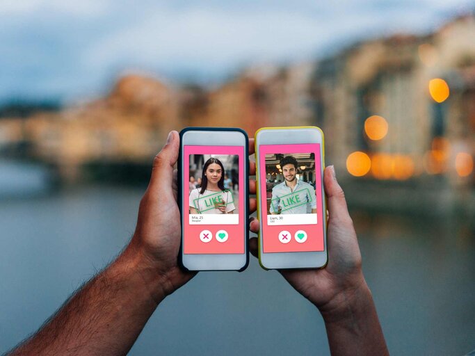 Zwei Hände halten Smartphones mit Dating Apps | © Getty Images/FilippoBacci