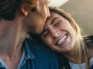 Junger Mann küsst Partnerin auf die Stirn | © Getty Images/Timm Creative