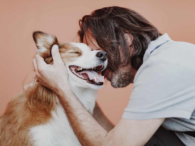 Mann kuschelt mit Hund | © Adobe Stock/kazantsevaov