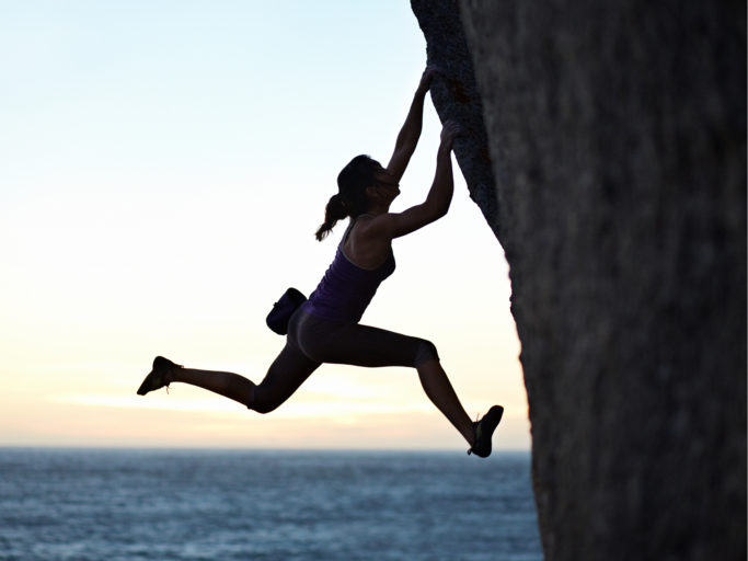 Silouhette einer Frau, die einen Berg hinaufklettert | © Getty Images/Klaus Vedfelt