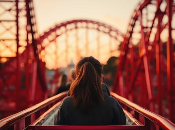 Frau sitzt in einem Achterbahnwagon | © Adobe Stock/Yuliia