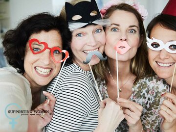 Vier Frauen mit Masken machen ein lustiges Foto. | © Getty Images / Silke Woweries
